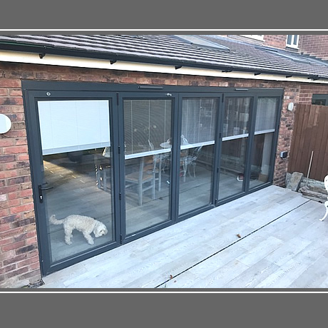 A 5 pane Smart Aluminium bi-folding door in anthracite grey finish with integral blinds installed in solihull, www.solihullwindows.co.uk