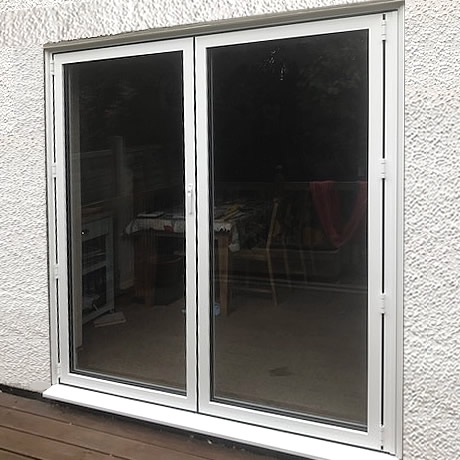 A 2 pane Smart Aluminium bi-folding door finished in White installed in solihull, www.solihullwindows.co.uk